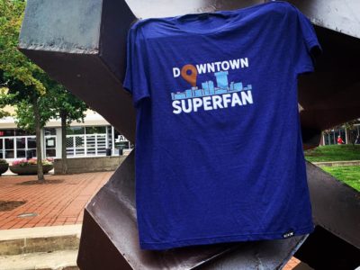 A blue Downtown Superfan T-shirt hangs on the Tumbler in Park Central Square